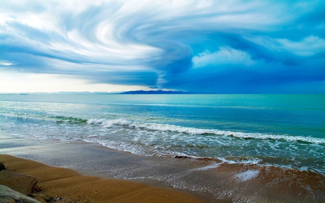 swirling-clouds-above-the-ocean-beach-wallpaper-3111